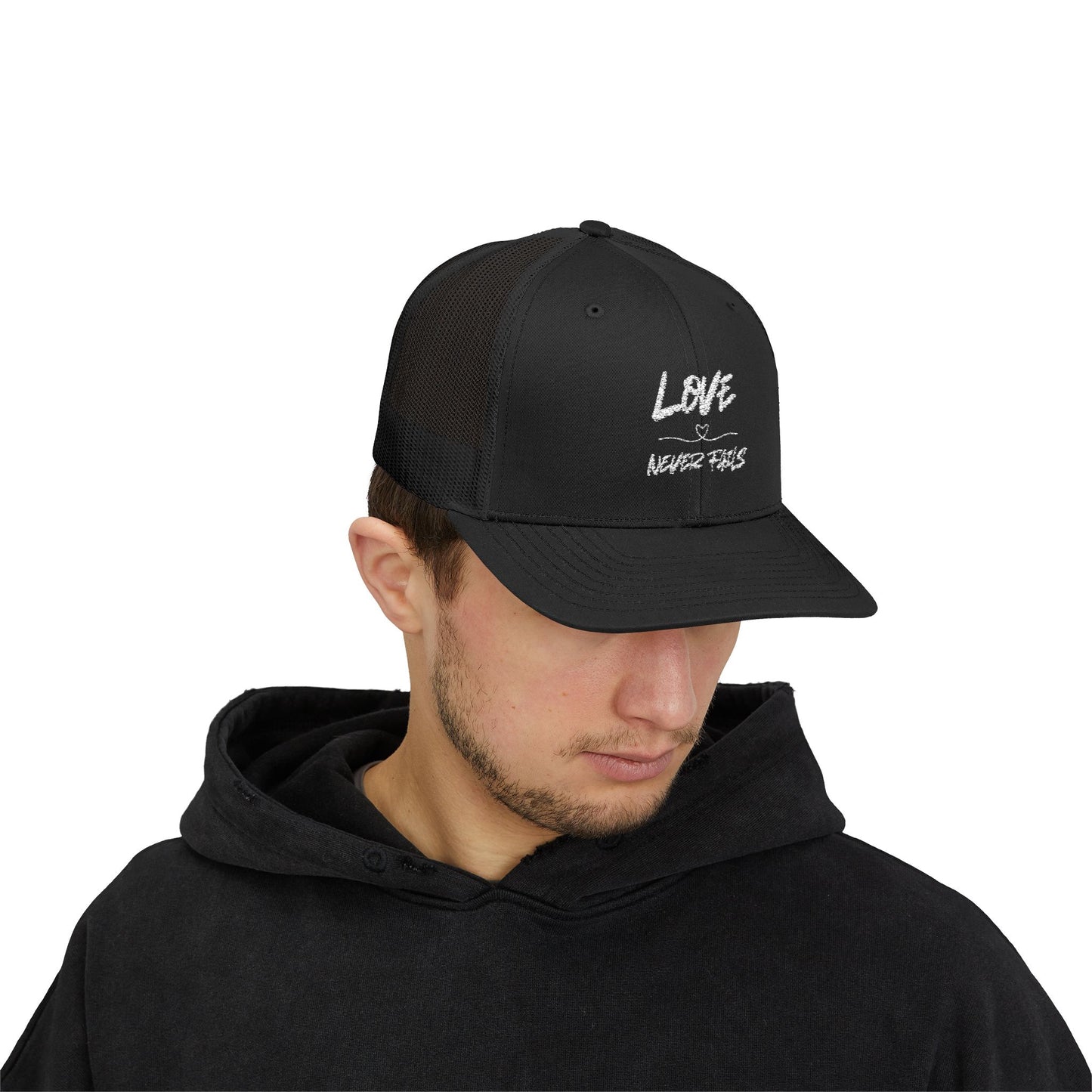 LOVE NEVER FAILS TRUCKER HAT