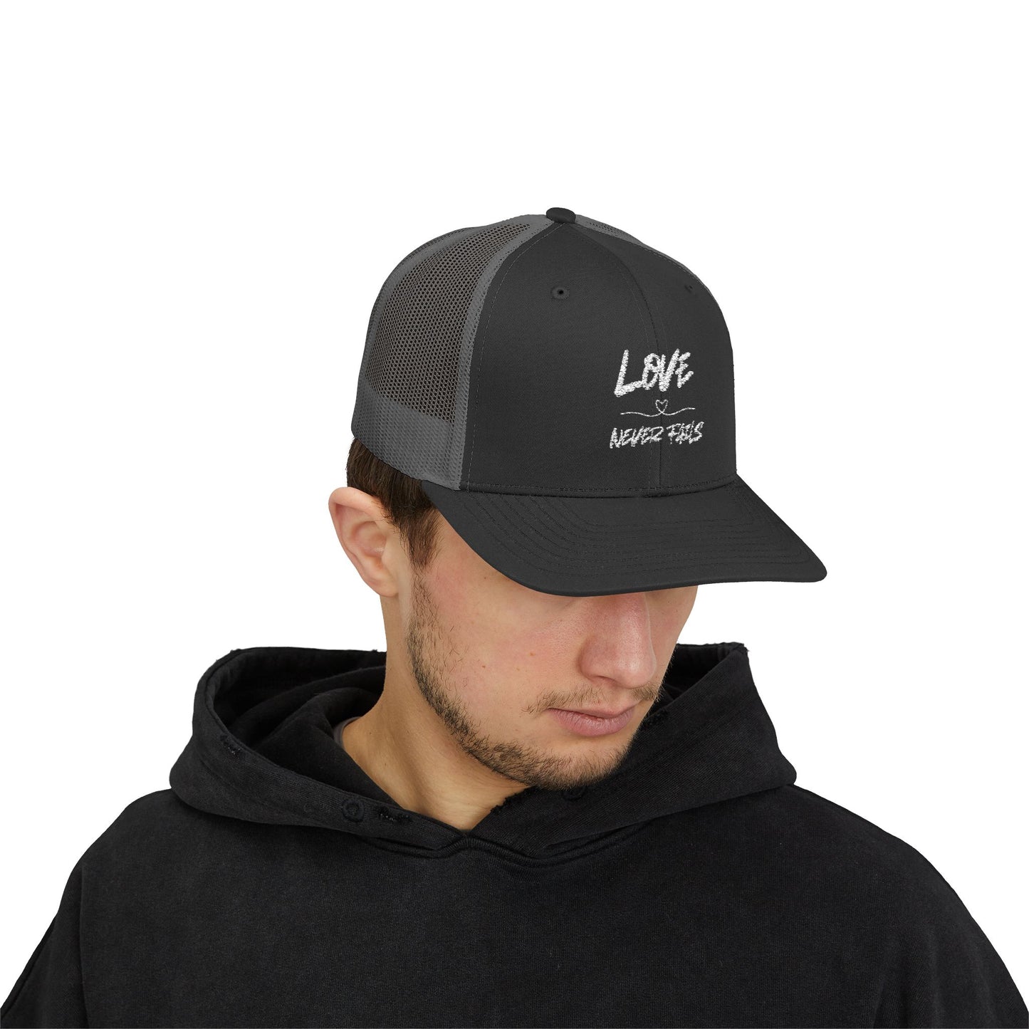 LOVE NEVER FAILS TRUCKER HAT